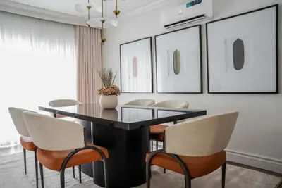Dining table at Dahlia by the window, seats in cream and orange leather