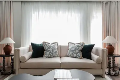 Cream sofa at Dahlia with patterned cushions and matching table lamps
