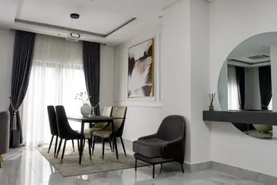 Dining area at Magnolia with a round mirror, console shelf and armchair