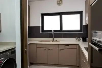 Kitchen at Magnolia with fitted cabinets, oven and washing machine